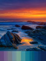 Dramatic ocean sunset with vibrant orange and purple sky reflecting on rocky coastline waves. Natural seascape with color palette for design inspiration.