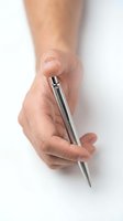 Close-up of a male hand holding a silver ballpoint pen against a white background, suitable for business, writing, and office concepts.