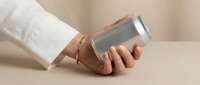 Hand holding modern smartphone with minimalist design on neutral beige background. Contemporary mobile technology and digital communication concept.