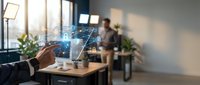 Businessman holding tablet with digital holographic data visualization and network connections in modern office workspace with colleagues.