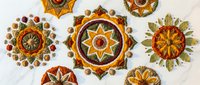 Decorative mandala ornaments with intricate geometric patterns in warm autumn colors featuring floral motifs and traditional folk art designs.