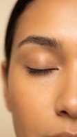 Close-up of serene woman with closed eyes showcasing natural makeup and glowing skin for beauty and skincare concepts.