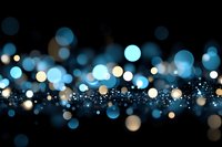 Abstract blue and gold bokeh lights with sparkling glitter effects on black background for luxury design projects and festive celebrations.