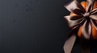 Elegant bronze satin bow adorning orange gift box against dark background, perfect for luxury holiday or special occasion marketing.