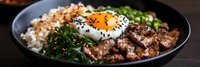 Korean beef bowl with sunny side up egg, steamed rice, seaweed, and fresh green onions served in dark ceramic bowl against black background.
