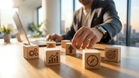 Professional businessman arranging wooden blocks with business strategy icons on modern office desk for corporate planning and goal achievement.