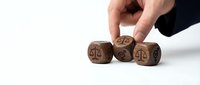 Hand placing wooden dice with percentage symbols on white background for business finance and probability concepts.