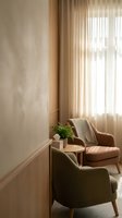 Cozy modern living room corner with comfortable armchairs, natural light filtering through sheer curtains, and minimalist decor for home interior design.
