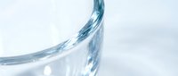 Abstract blue water splash with dynamic flowing motion and transparent droplets on clean white background for modern design projects.