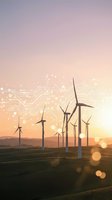Wind turbines on green field at sunset with digital circuit overlay representing renewable energy technology and sustainable power generation.
