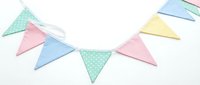 Pastel colored bunting garland with triangular flags in pink, blue, and mint green polka dot fabric strung together on white background for celebrations.
