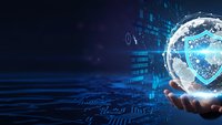 Digital cybersecurity concept with glowing shield protection symbol in transparent sphere above human hand against dark blue technology background.