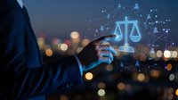 Businessman hand touching digital justice scales with network connections against blurred city lights background representing legal technology solutions.