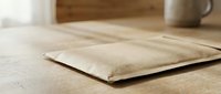 Natural linen fabric pillow case on wooden table in cozy home interior setting for bedding and textile design projects.