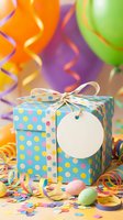 Colorful birthday gift box with polka dots, blank tag, balloons and party decorations for celebration events and festive occasions.