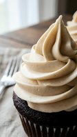 Chocolate cupcake topped with swirled peanut butter frosting, served on white plate with fork, ideal for bakery, dessert, and food styling projects.