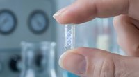 Scientist hand holding DNA sample vial in modern laboratory for genetic research and biotechnology analysis.