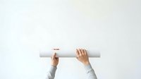 Overhead view of hands holding rolled white paper or blueprint against neutral background, suitable for architecture, construction, planning, and business concepts.