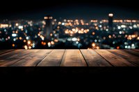 Empty wooden table overlooking blurred city lights at night, creating atmospheric bokeh effect background for product display or montage purposes.