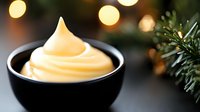 Soft serve vanilla ice cream swirl in black ceramic bowl against blurred Christmas lights and pine branches background, festive winter dessert setting.