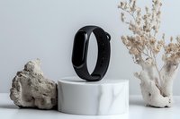 Smart fitness tracker on marble pedestal with decorative coral and dried flowers in minimal composition against white background for wellness technology marketing.