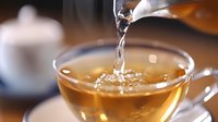 Hot herbal tea being poured from glass teapot into transparent cup creating splash and steam in warm cozy kitchen setting for relaxation and wellness.