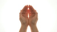 Cupped hands holding glowing light beam on white background. Spiritual energy, healing power, protection concept for wellness and meditation designs.