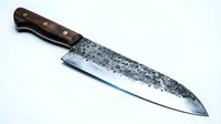 Chef's knife with dark wooden handle and weathered steel blade on white background, suitable for culinary and kitchen design projects.