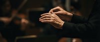 Elderly hands in prayer position showing wrinkled skin and spiritual devotion in warm lighting for meditation and faith concepts.