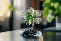 Crystal glass clover decoration on dark surface with blurred background, elegant home decor piece featuring transparent petals and green center.