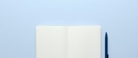 Open notebook with blank pages and dark pen on light blue background, ready for writing, planning, or design mockups.