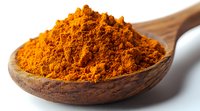 Ground turmeric powder in wooden spoon macro view on white background. Bright orange aromatic Indian spice used in cooking and alternative medicine.
