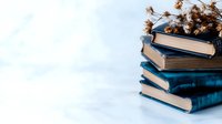 Stack of vintage books with dried flowers on white background for education, literature and reading concepts.
