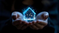 Glowing blue hologram house floating above cupped hands against dark background, symbolizing smart home technology and real estate innovation.