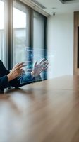 Business professional analyzing holographic data visualization interface with charts and graphs in modern office environment.