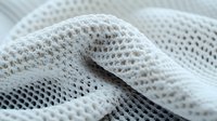 Macro view of white mesh fabric texture with soft folds creating abstract pattern. Clean modern minimalist composition showing detailed textile structure.