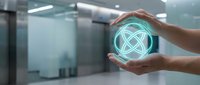 Hands holding glowing neon atom symbol in modern office space, representing science, technology, innovation, and future research development.