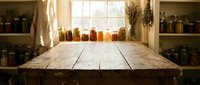 Rustic wooden table in pantry with glass jars on shelves, sunlight through window, storage organization for kitchen and home decor.