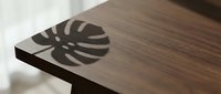 Wooden table with monstera leaf shadow cast on surface, natural light creating botanical silhouette for interior design and home decor projects.