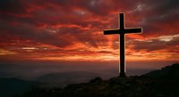 Cross silhouette against dramatic sunset sky with vibrant red and orange clouds over mountain landscape for religious and spiritual concepts.