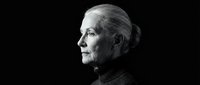Senior Caucasian woman in profile against dark background, contemplative expression, dramatic lighting for portraits and aging concepts.