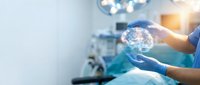 Surgeon hands holding glowing brain hologram in modern operating room with medical equipment and bright surgical lights for healthcare technology concepts.