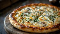 Homemade white pizza with mushrooms and herbs on wooden board, golden crust and melted cheese create gourmet Italian dining experience.