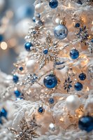 Elegant Christmas tree decorated with blue and silver ornaments, crystal snowflakes, and warm glowing lights creating magical winter holiday atmosphere.
