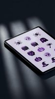Digital tablet displaying purple Halloween icons including spiders, skulls, pumpkins and bats on screen for seasonal app design and mobile interface development.