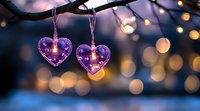 Purple heart-shaped lights hanging from tree branch against blurred bokeh background creating romantic atmosphere with warm evening glow and magical ambiance.
