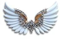 White angel wings decorated with golden elements and sparkling crystals, isolated on white background for design projects, jewelry inspiration and creative use.