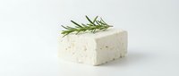 Creamy white cheese block with fresh rosemary herb garnish on isolated white background, ready for food and culinary design projects.