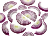 Fresh red onion slices with purple layers isolated on white background for cooking and culinary design projects.