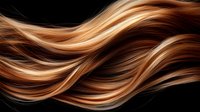 Flowing strands of caramel and chocolate brown hair with blonde highlights creating smooth wavy pattern on black background, showcasing professional hair coloring technique.